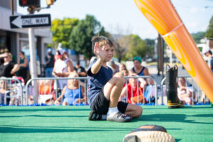 A boy waving to the crowd at the Grand Slam Parade
