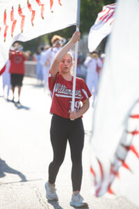 A Williamsport Little League player waving a baseball flag